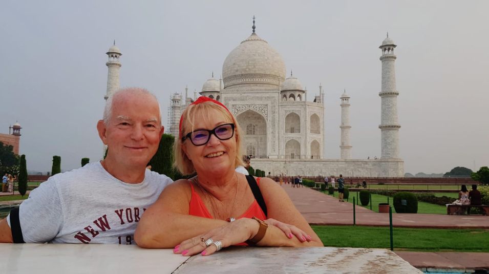 Happy Crystal India Holidays couple enjoying a close-up moment in front of the Taj Mahal during evening light, Agra